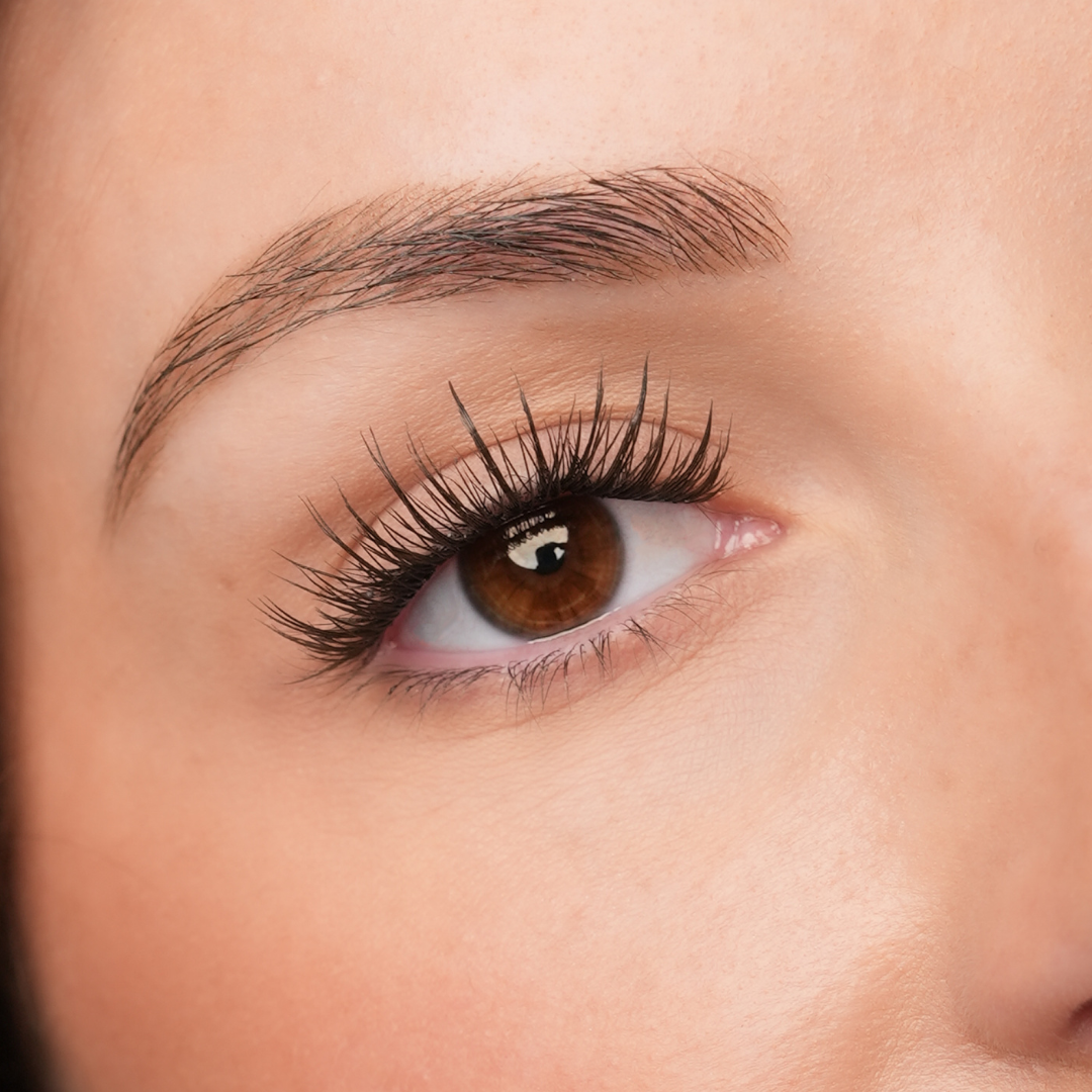 Close-up of a person's eye with long, dark eyelashes